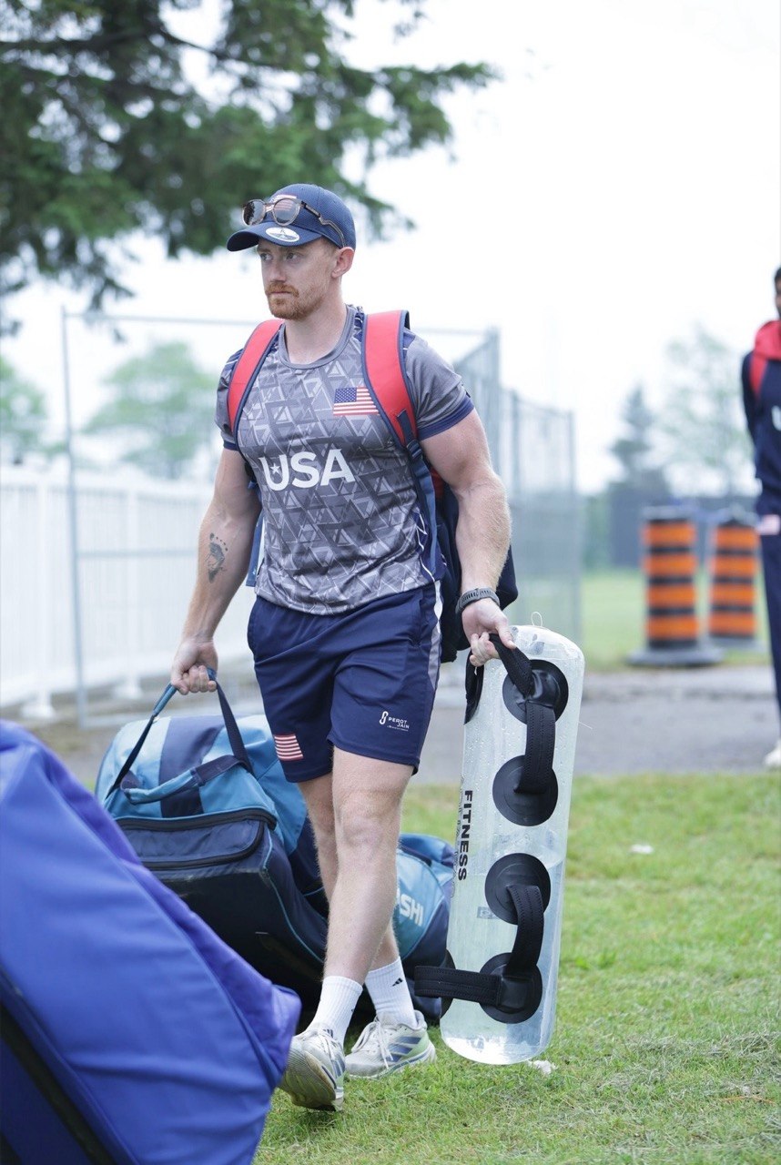 Mathew Skyner carrying training equipment in a USA Cricket environment